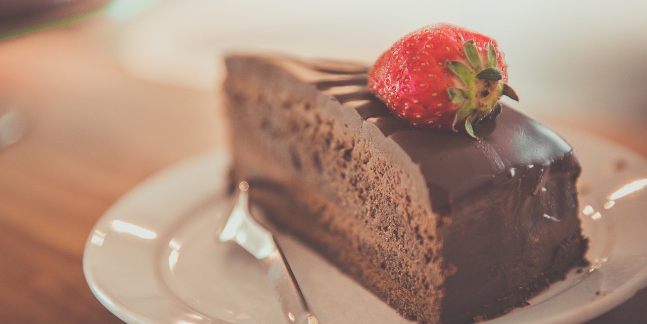 イチゴが乗ったチョコレートケーキの写真